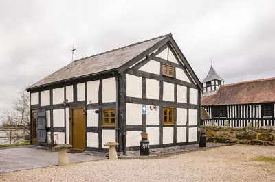 a black and white building with a yellow door at River Cottage, Melverley in Melverley