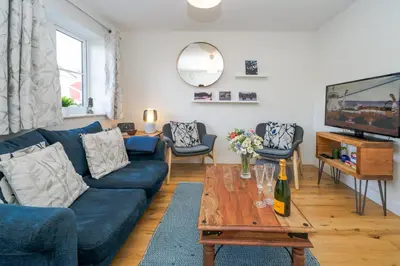 a living room with a blue couch and a table at Modern and bright 2-bed home near Ludlow centre - Pass the Keys in Ludlow