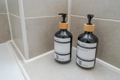 two bottles of alcohol sitting on a bathroom counter at Modern and bright 2-bed home near Ludlow centre - Pass the Keys in Ludlow