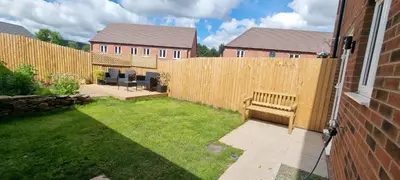 a backyard with a wooden fence and a bench at Modern and bright 2-bed home near Ludlow centre - Pass the Keys in Ludlow