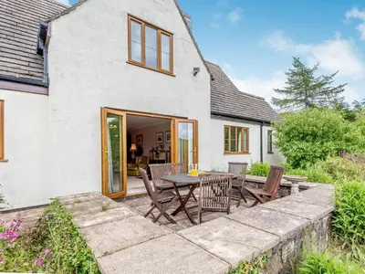 a patio with a table and chairs in front of a house at Cwmfron House in Llanidloes