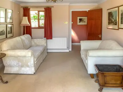 a living room with two couches and a table at Cwmfron House in Llanidloes
