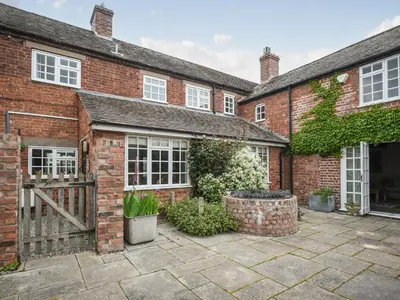a brick house with a gate and a courtyard at Home Farm House in Dorrington