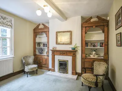 a living room with a fireplace and two chairs at Home Farm House in Dorrington