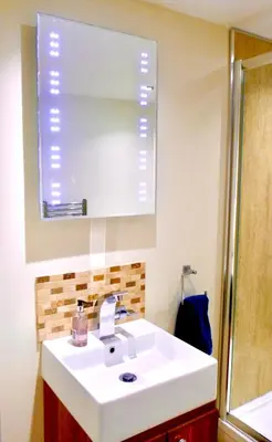 a bathroom with a white sink and a mirror at “Dragons Den” Centrally located Modern Apartment in Aberystwyth