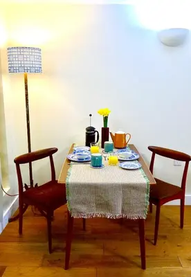 a table with a table cloth on it with two chairs at “Dragons Den” Centrally located Modern Apartment in Aberystwyth