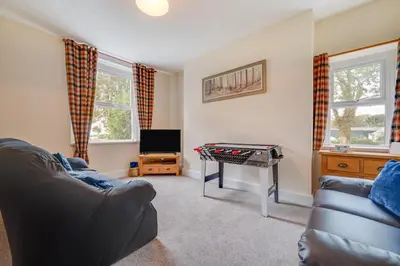 a living room with a leather couch and a table with a chessboard at 5 Bed in Llandovery oc-bow323 in Llangadog