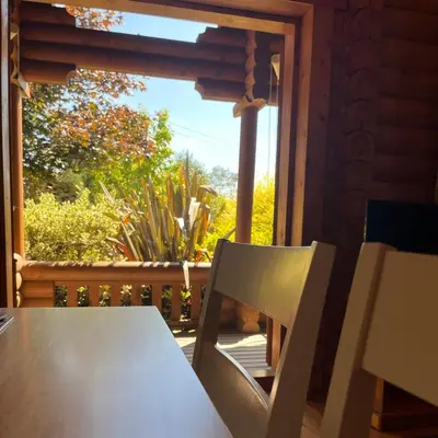 a table and a chair in front of a window at Countryside Log Cabin With Hot Tub - Beech in Leominster