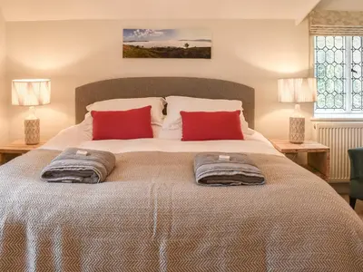 a bedroom with a large bed with two pillows on it at Crogen Gatehouse Lodge in Corwen