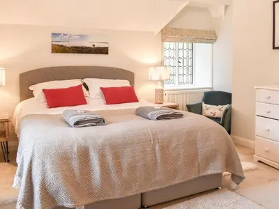 a bedroom with a large bed with red pillows at Crogen Gatehouse Lodge in Corwen