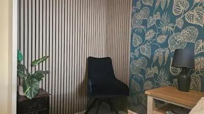 a black chair in a room with a wall at Talarfor Barmouth in Barmouth