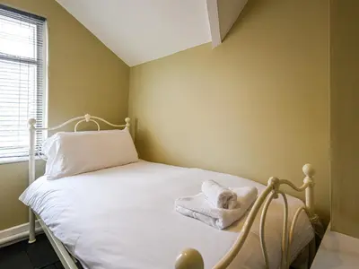 a bedroom with a white bed with towels on it at Bwthyn Llys Machynlleth Old Court House in Machynlleth