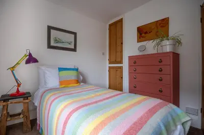 a bedroom with a colorful bed and a dresser at Cottage in heart of Dolgellau with parking in Dolgellau