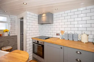 a kitchen with white tiled walls and a counter top at Cottage in heart of Dolgellau with parking in Dolgellau