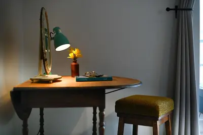 a desk with a mirror and a lamp and a chair at Cottage in heart of Dolgellau with parking in Dolgellau