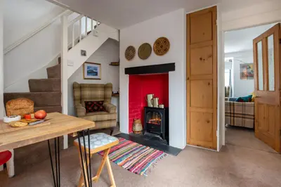 a living room with a fireplace and a table at Cottage in heart of Dolgellau with parking in Dolgellau