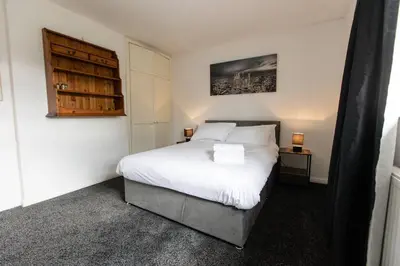 a bedroom with a large white bed and a night stand at Cul-de-sac Creations in Shrewsbury