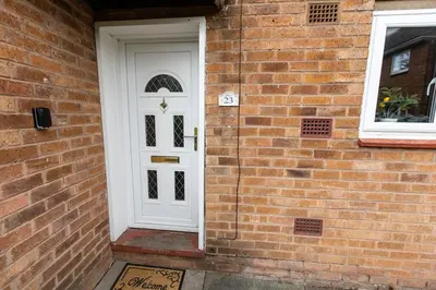 a white door on the side of a brick building at Cul-de-sac Creations in Shrewsbury