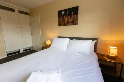a bedroom with a large white bed with two lamps at Cul-de-sac Creations in Shrewsbury