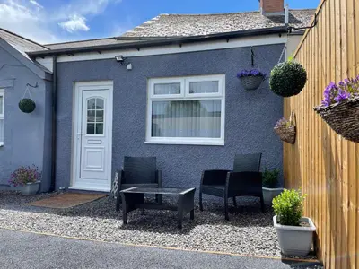 a blue house with chairs and a table in front of it at Westend Holiday Let 4 Brecon in Brecon