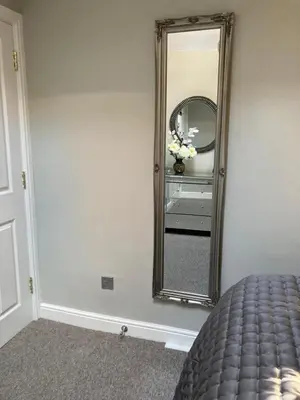 a bedroom with a mirror on the wall at Rooftops - bijou sister apartment to Assembly View - free parking permit provided in Ludlow