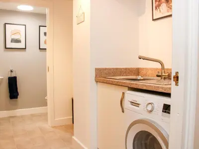a laundry room with a sink and a washing machine at 6 The Engine Shed in Shrewsbury