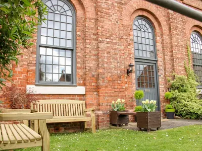 a brick building with two benches in a yard at 6 The Engine Shed in Shrewsbury