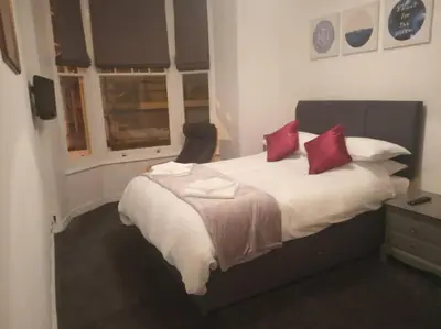 a bedroom with a large bed with red pillows at Apartment One Aberystwyth Town Centre in Aberystwyth