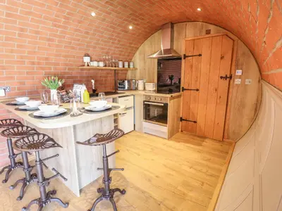 a kitchen with a counter and stools in a room at Nant yr Esgair in Machynlleth
