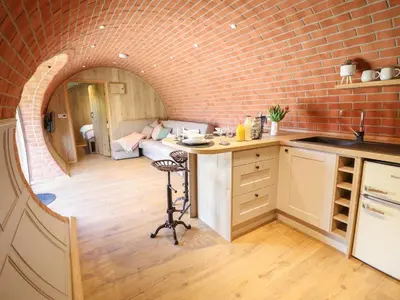 a kitchen and living room with a brick wall at Nant yr Esgair in Machynlleth