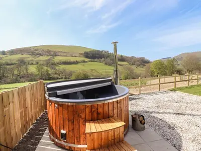 a wooden tub sitting on top of a patio at Nant y Garnedd in Machynlleth