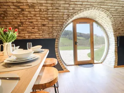 a dining room with a table and a mirror at Nant y Garnedd in Machynlleth