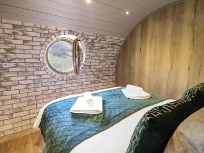 a bed in a small room with a mirror at Nant y Garnedd in Machynlleth