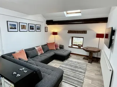 a living room with a couch and a tv at Converted barn, perfect MTB break, Coed y Brenin in Trawsfynydd