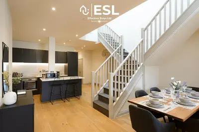 a kitchen and dining room with a staircase in a house at Dashing 2 Bedroom Duplex Apartment, Free Parking in Shrewsbury