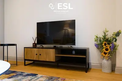 a living room with a television on a tv stand at Dashing 2 Bedroom Duplex Apartment, Free Parking in Shrewsbury