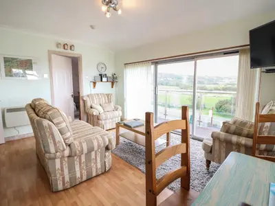 a living room with a couch and chairs and a table at Morlyn Guest House Apartment in Harlech