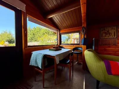 a dining room with a table and chairs and windows at Shifty Chicken Shack in Trawsfynydd