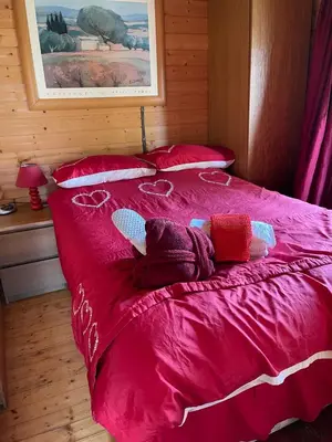 a red bed with two dolls laying on it at Ty Bach Twt, Coity Bach in Brecon