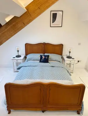 a bedroom with a wooden bed with two tables at Swn Y Don New Quay in New Quay