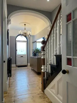 a hallway with a white door and a chandelier at Swn Y Don New Quay in New Quay