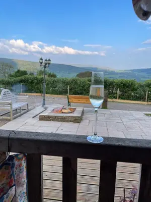 a glass of wine sitting on top of a table at Ty Nofio, Coity Bach in Brecon