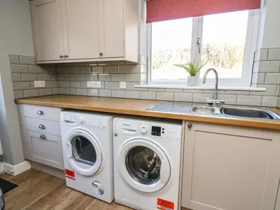 a kitchen with a washing machine and a sink at Talarddu Cottage in Builth Wells