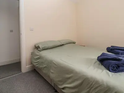 a small bedroom with a bed in the corner at Cae Iocyn in Wrexham