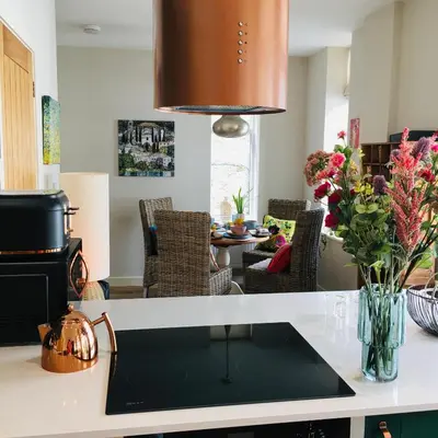 a kitchen with a counter top with a table with flowers at The Art Attic a Stylish Boutique Apartment in Builth Wells