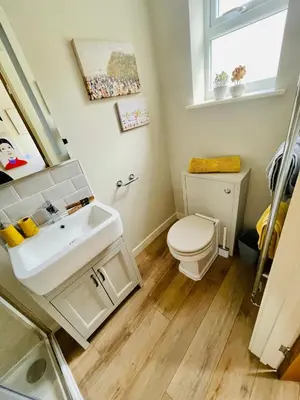 a bathroom with a white sink and a toilet at The Art Attic a Stylish Boutique Apartment in Builth Wells