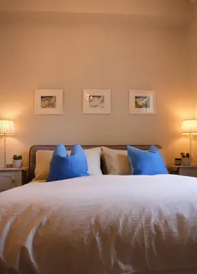 a bedroom with a large bed with blue pillows at Seaside Apartment in Aberystwyth