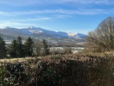 a view of snow covered mountains from a field at Beaconsview B&B in Brecon