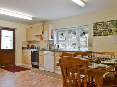 a kitchen with a table and a dining room at Blackbird Cottage in Llanfair Caereinion