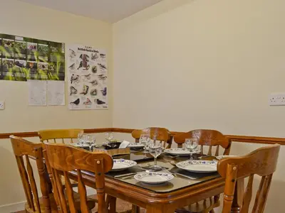 a dining room table with wine glasses on it at Blackbird Cottage in Llanfair Caereinion